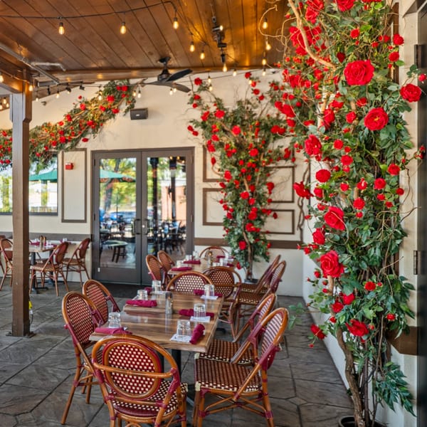 Guapo's Cocina & Bar's outdoor patio with tables, chairs, and red rose decorations.