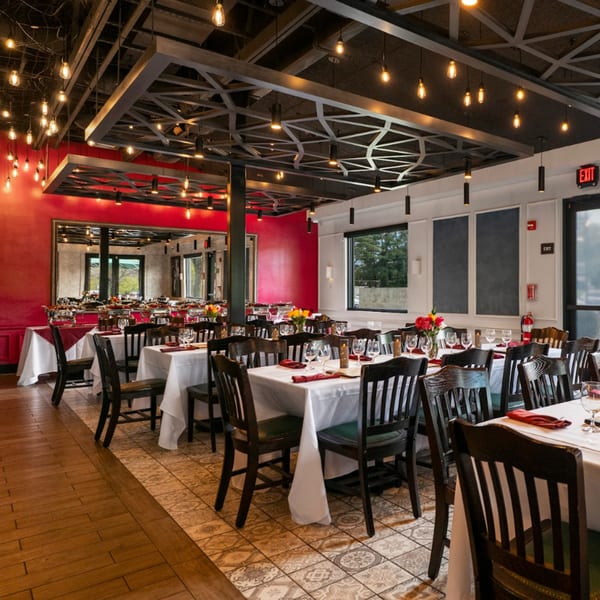 Guapo's Cocina & Bar dining room with red walls, set tables, and decorative lighting.