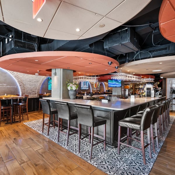 Interior of Guapo's Cocina & Bar, featuring a long bar with stools and dining tables.