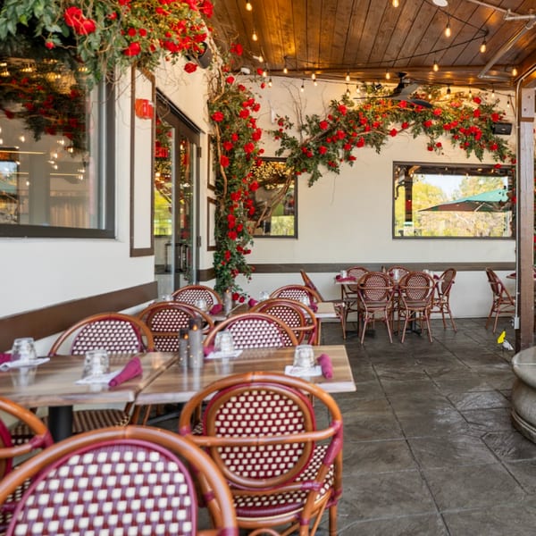 Guapo's Cocina & Bar's outdoor patio with red rose garlands, string lights, and dining tables.