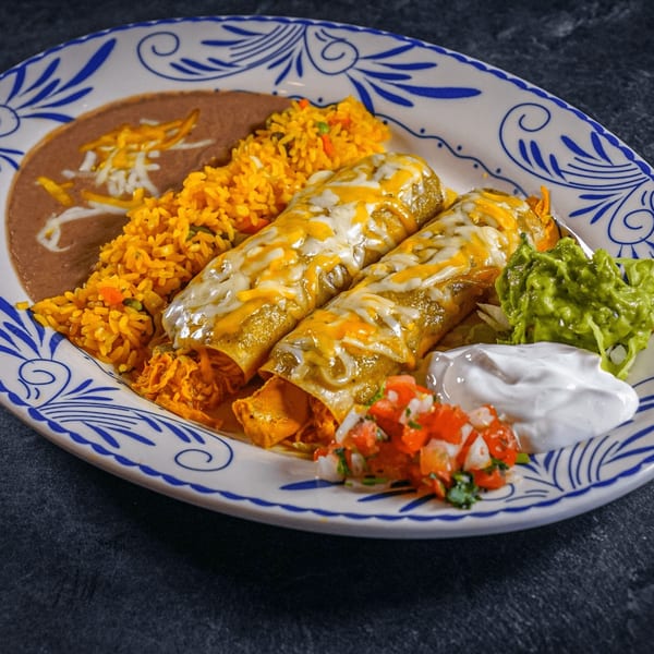Two cheesy enchiladas with rice, refried beans, guacamole, sour cream, and pico de gallo.